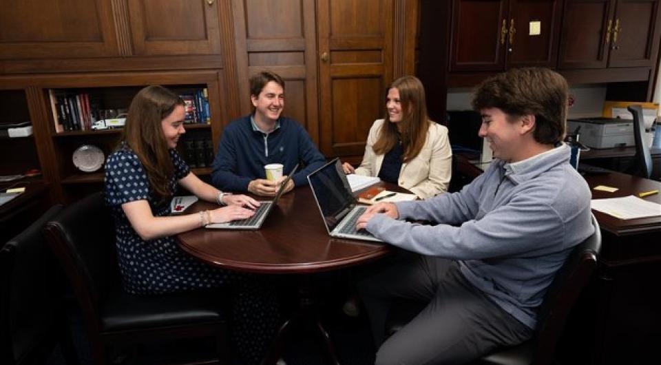 Interns working together while sitting around a table.