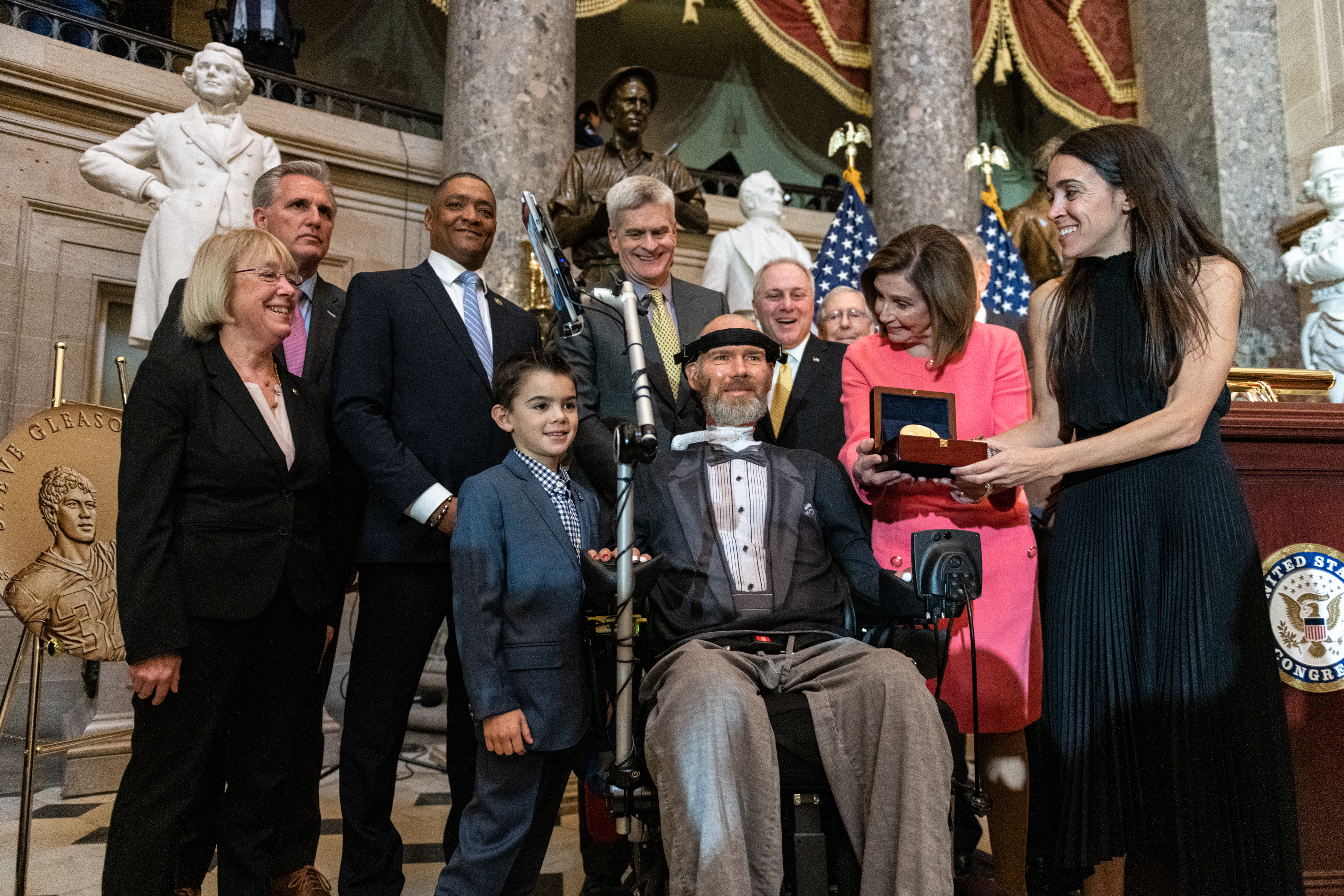 Steve Gleason, members of Congress, and the Gleason family gather around Steve.