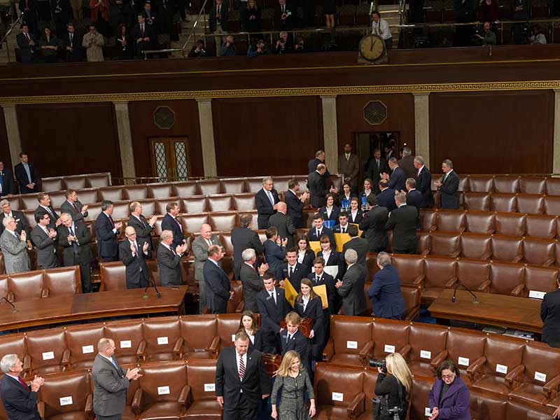 Members of the U.S. Senate standing together in the House Chamber